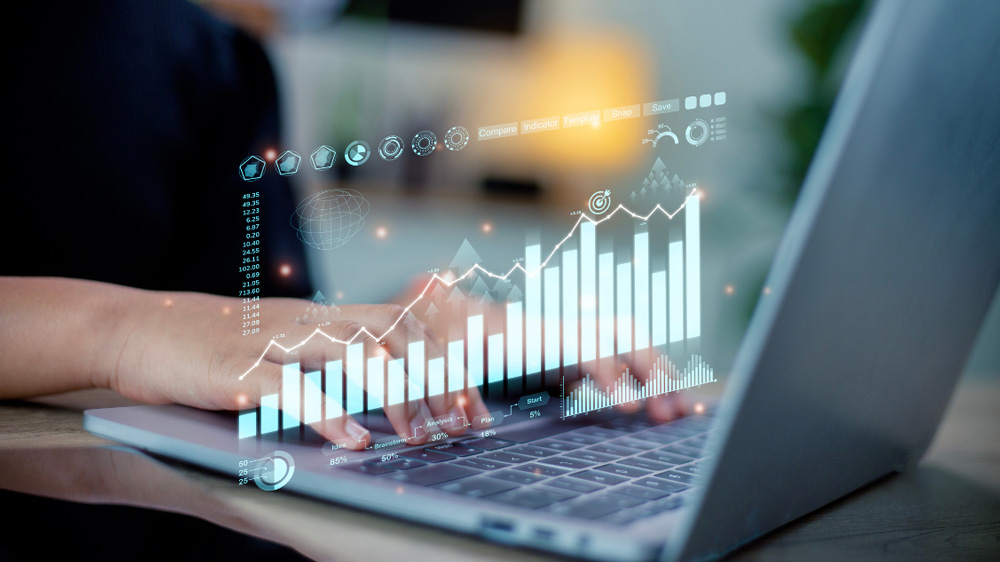 Hands typing on a laptop with floating data visualisations, representing cybersecurity and data analysis. The image illustrates insights from the ASD Cyber Threat Report 2023-2024, highlighting trends, impacts, and responses to cybercrime affecting Australia.